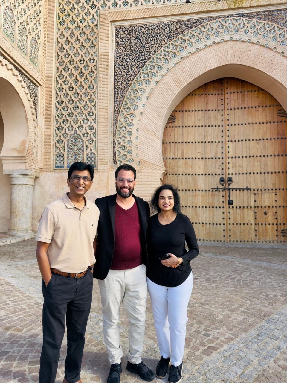 Guests standing in front of the brass doors of the Royal Palace gate in Fes
