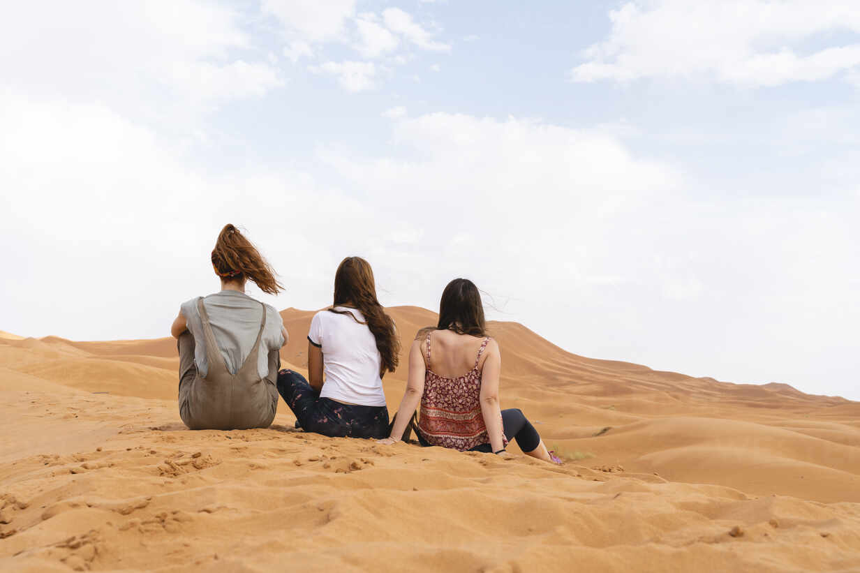 Sahara Desert, Morocco. Group of young woman travelling together. Explore, travel, adventure, holidays, Merzouga, desert, Sahara, dunes