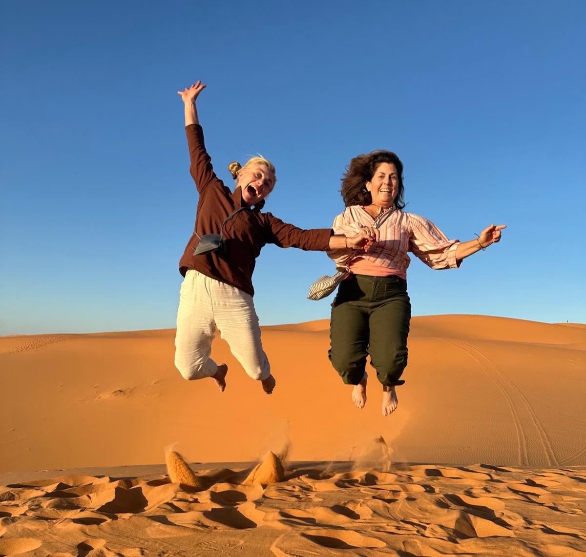 Traveler riding a camel at sunset in the Sahara Desert on a Best Morocco Desert tour